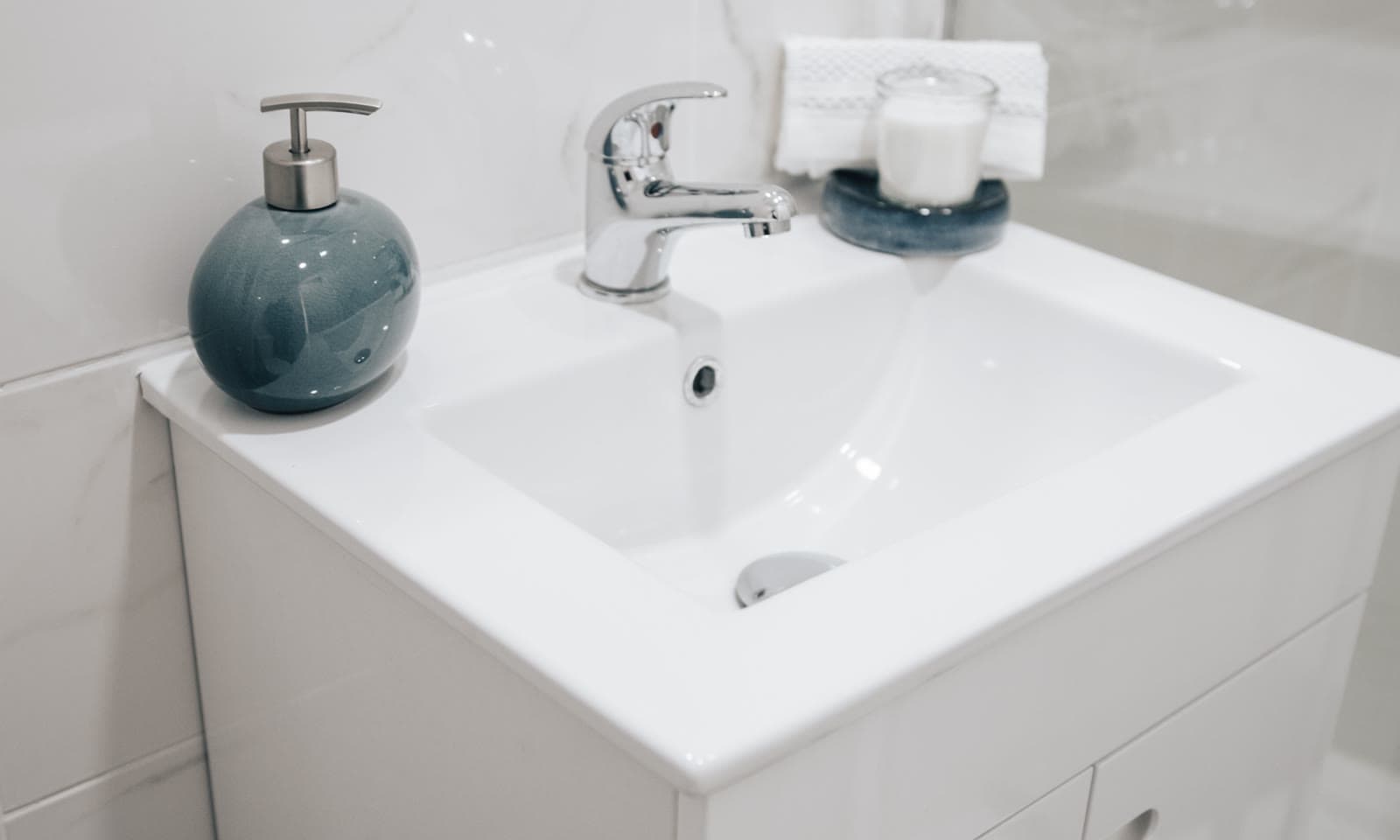 Spotless white bathroom sink and fixtures, detail-cleaned