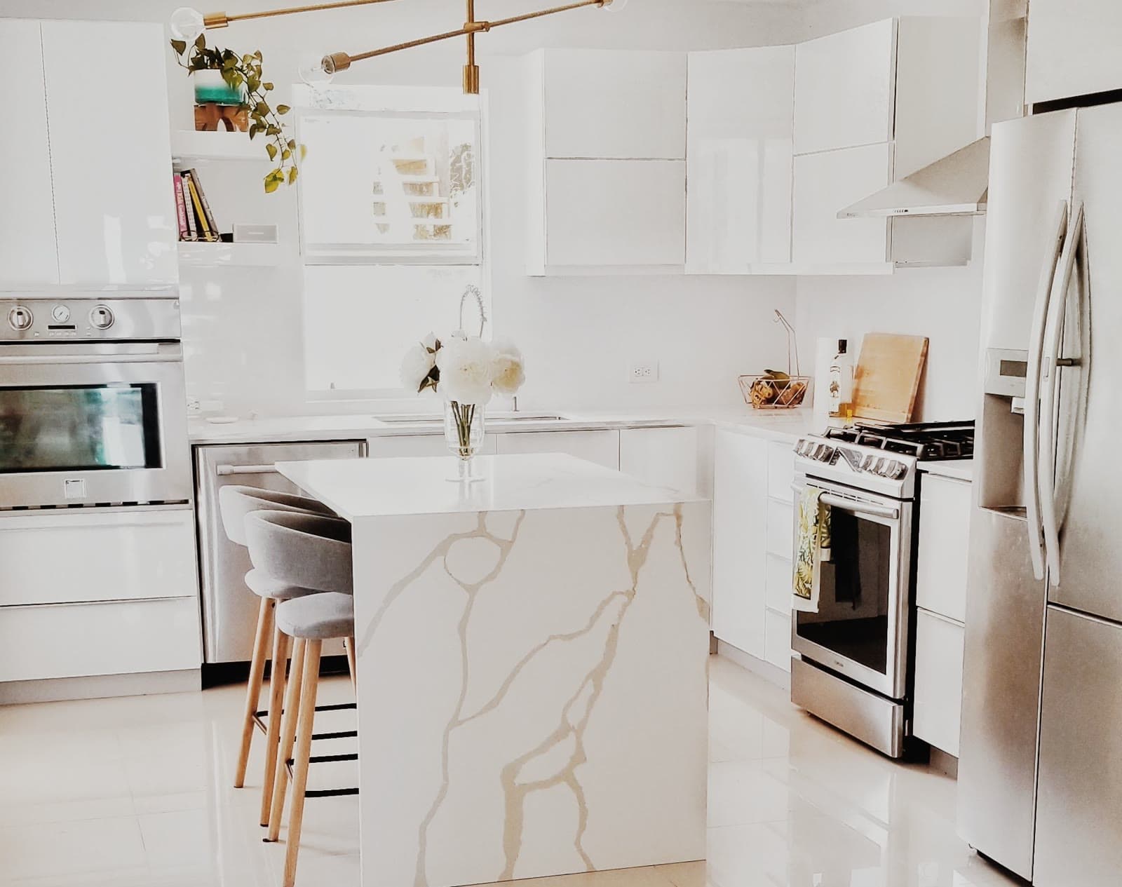 Bright white kitchen with a marble island, freshly cleaned and ready